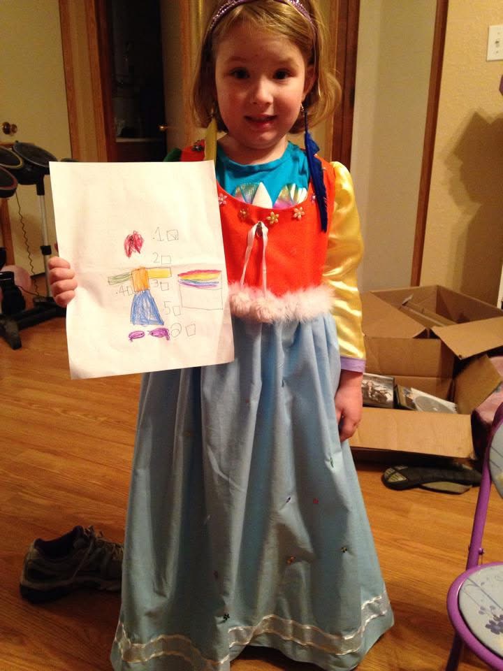 Child holding crayon drawing of her first dress design