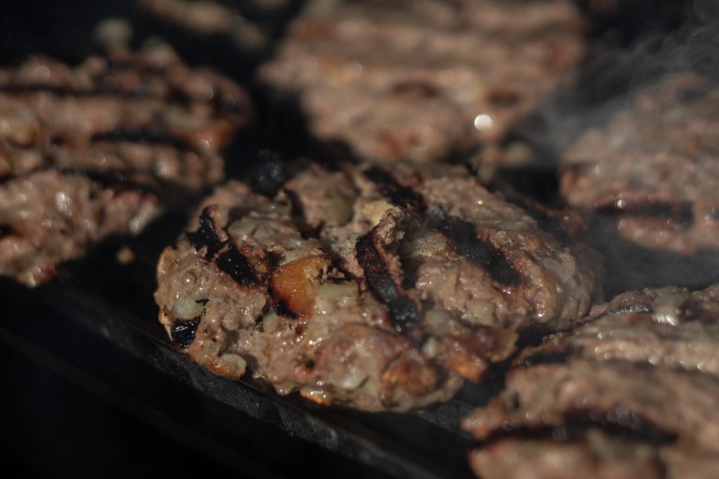 Close-up of a lion’s mane burger with bold grill marks.
